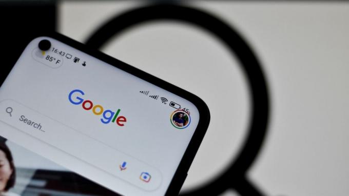 Logo Google dengan kaca pembesar di latar belakang