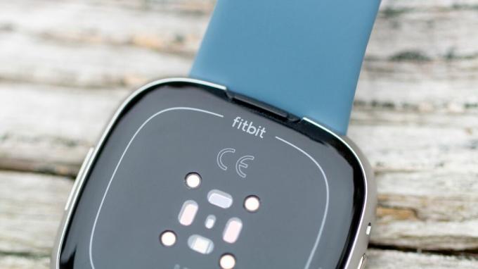 Prim-plan pe sigla Fitbit deasupra senzorilor Versa 4
