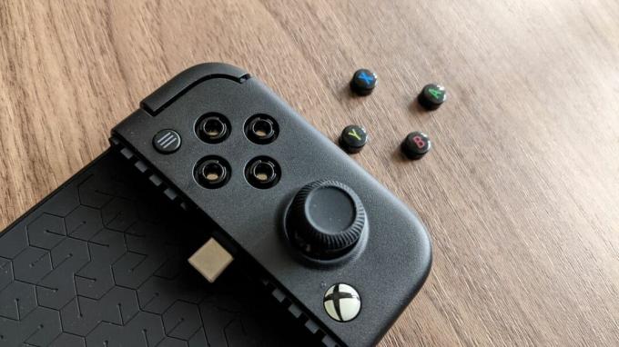 GameSir X2 Pro z odstranjenimi obraznimi gumbi leži zraven