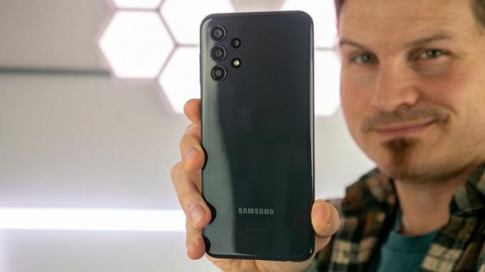 De Samsung Galaxy A13 vasthouden en de glanzende achterkant laten zien