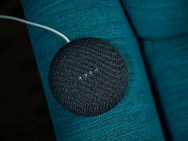 En Google Home Nest Mini-høyttaler på blått bakteppe